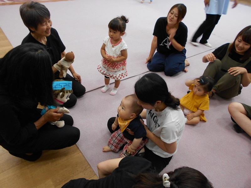 観劇している親子の所に人形劇の人形にて話かけている写真