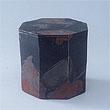 黒色に赤色などが彩色された八角形の筒状の箱の作品の写真