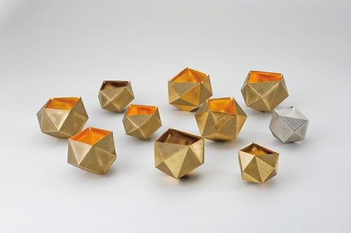 折り紙で作られたような三角の側面で作られた、いくつものかわいい器の作品の写真