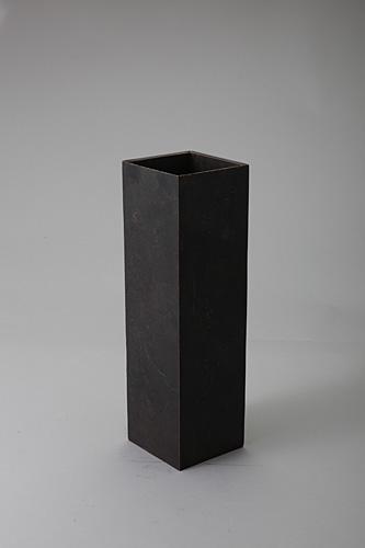 青銅でつくられた黒色の長方形の花器の作品の写真