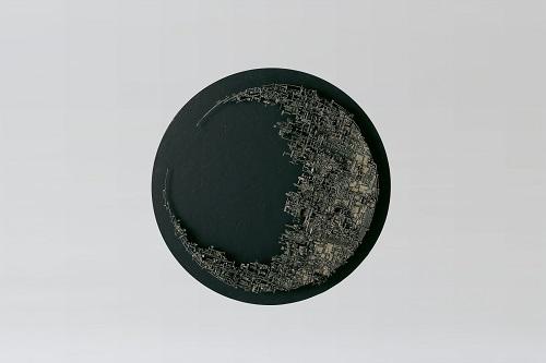 黒い丸の表面に三日月が浮かびあがっているようにみえる作品の写真