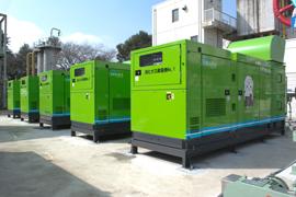 緑色をした消化ガス発電機が5基並んでいるところを右斜め前から撮った写真