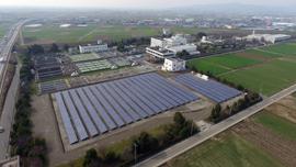 畑の中に設置された太陽光発電システムの全体を上空から撮影した写真