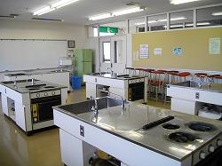 調理台が4つと前方に1つ、ホワイトボードがある実習室の写真
