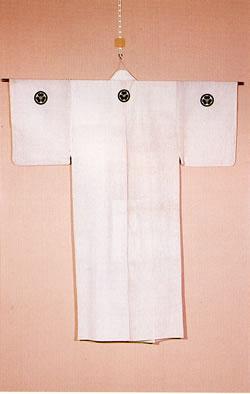 白地に田中家の定紋である「丸にかたばみ」が背中と両袖についている着物が衣文賭けに吊るされている写真