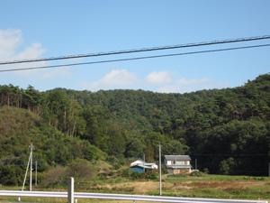 青い空と緑の山々ふもとに民家がポツンと2件並んでいる富士町にある大網山城跡の写真