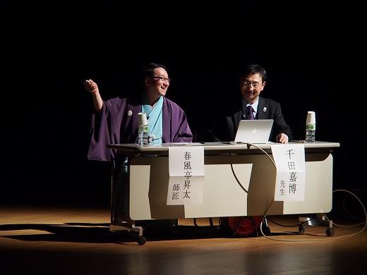 国指定史跡化記念事業記念フォーラムで壇上で講話する落語家の春風亭昇太さんと千田嘉博先生の写真