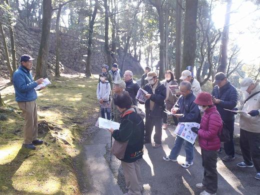 唐沢山城跡で行われたウィーキングで資料を手に実施前の説明をする主催者と話を聞いている参加者たちの写真