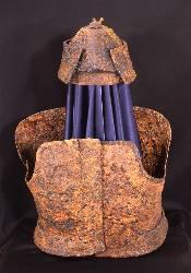 八幡山古墳から発掘された前頭部が突き出している鉄製の衝角付冑と短甲の写真