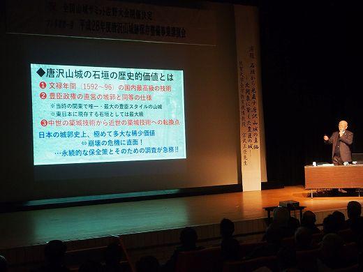 唐沢山城の石垣の歴史的価値についてスクリーンを使って講演をしている写真