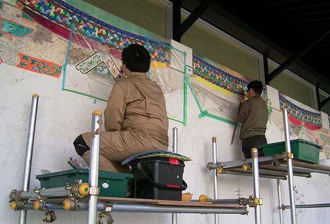 戸倉英雄さんと福島恒久さんが足場を組み高い部分を描いている写真