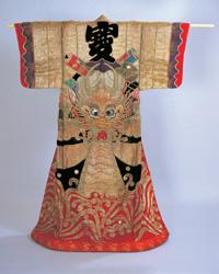 着物の背中に宝船の真ん中に竜の顔が描かれた牧歌舞伎(まぎかぶき)を掛けた全体写真
