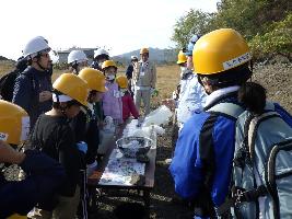 鉱山の説明を受ける参加者達の写真