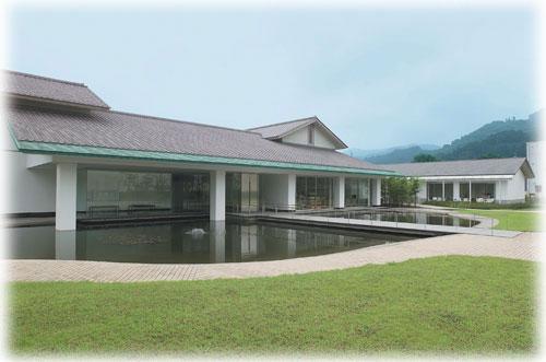 芝生が広がりエントランス部分が池になっている佐野市立吉澤記念美術館の外観の写真