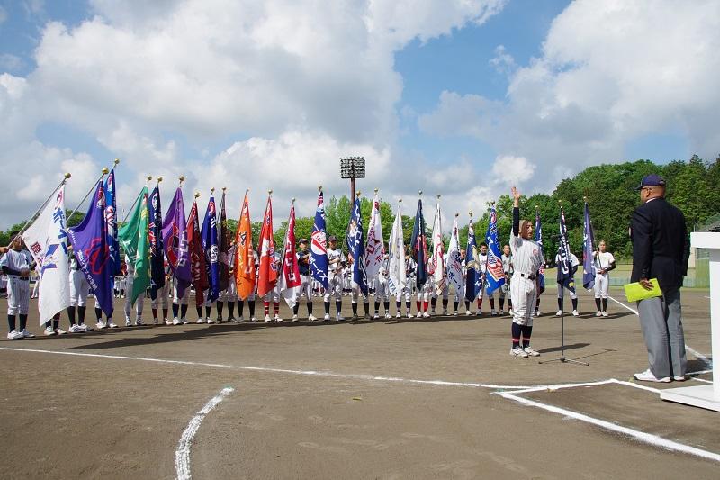 開会式で各チームの団旗を持った選手が集まり代表が選手宣誓をしている写真