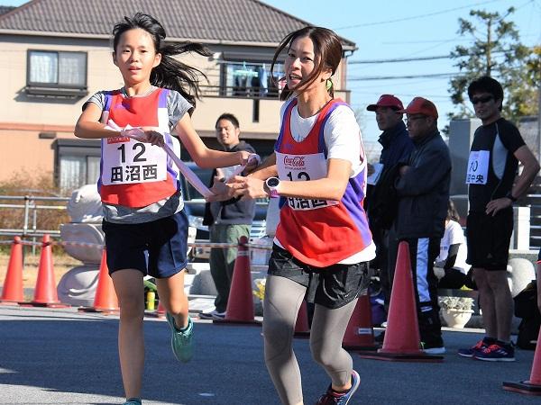 次の選手に襷を渡している女子選手の写真