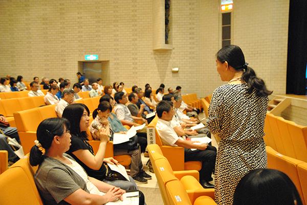 講演女性が客席に降り客席の女性の質問を聞いている写真