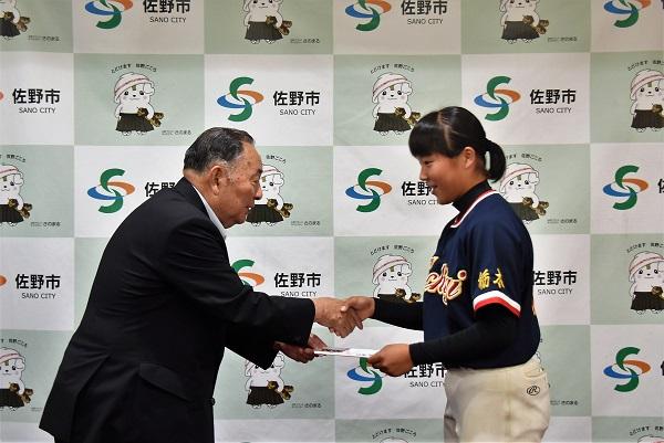 佐野市長と握手をし壮途金を受け取っている飯田ひかりさんの写真