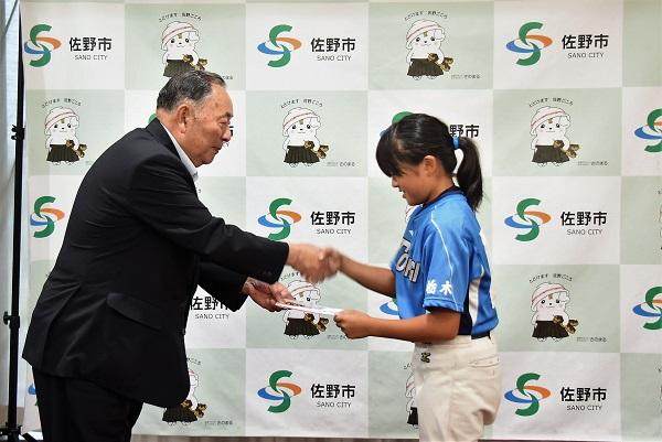 佐野市長と握手をし壮途金を受け取っている渡邊美音さんの写真