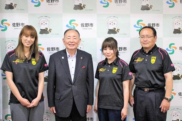 佐野市長と並び記念撮影をしている女子バレーボール部員2名と男性の写真
