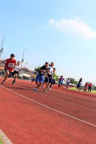 リレー女子の部でバトンを受け取り走り出す写真