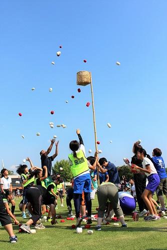 田沼西支部のチームが跳ねながら籠に向かって玉を投げ入れている写真