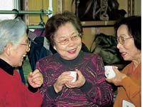 お茶を飲みながら談笑をする女性高齢者3人の写真