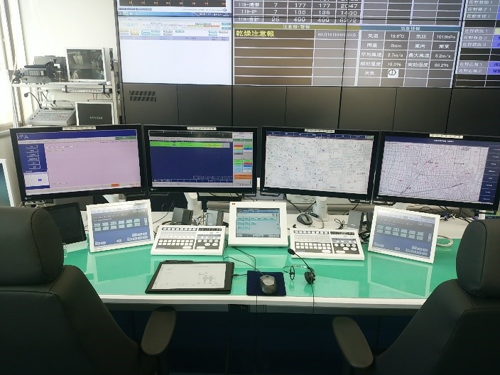 4台のモニターなど、情報を集めるための機器が準備されている指令台の写真